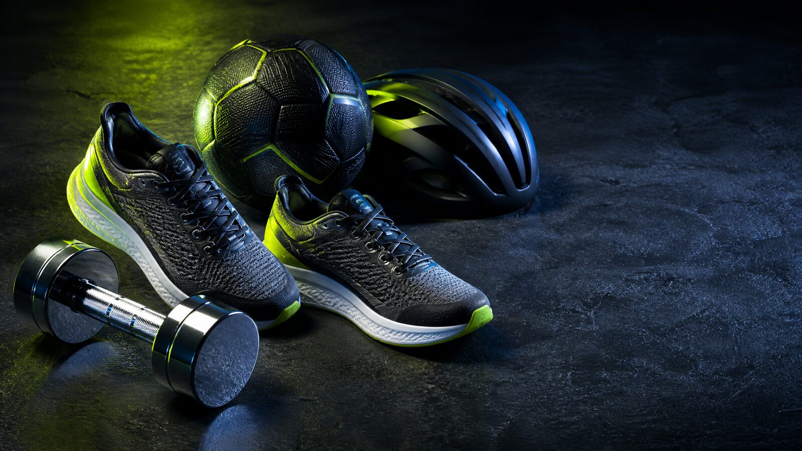 Dynamische sportuitrusting-stilleven: hardloopschoenen, halter, voetbal en fietshelm in energiek licht
